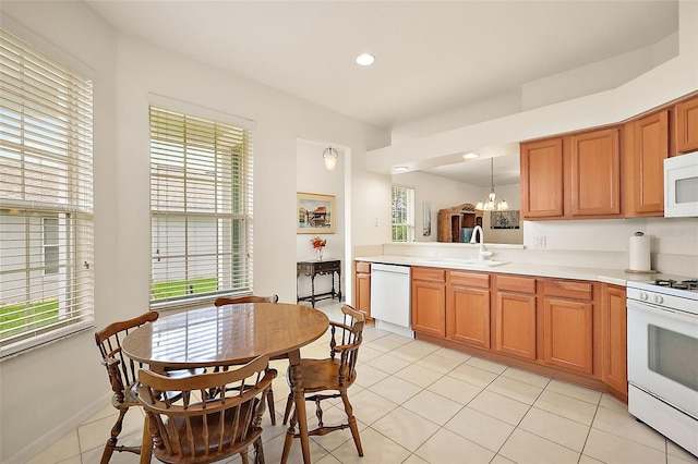 kitchen with pendant lighting, sink, white appliances, and a healthy amount of sunlight