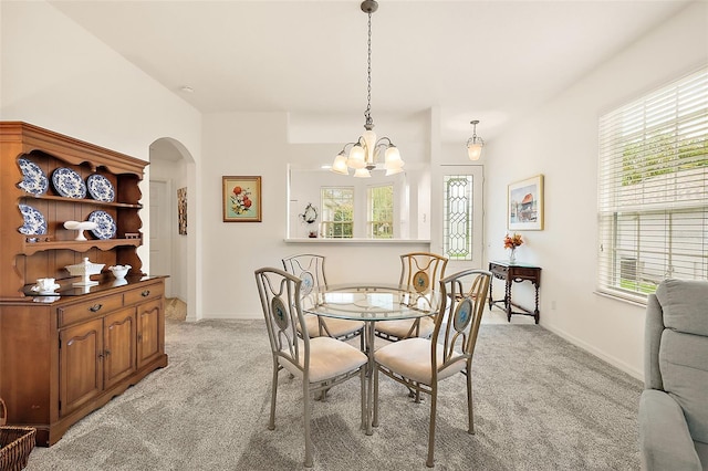 carpeted dining space with a wealth of natural light and a chandelier