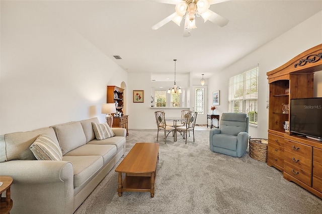 living room featuring ceiling fan with notable chandelier and light carpet