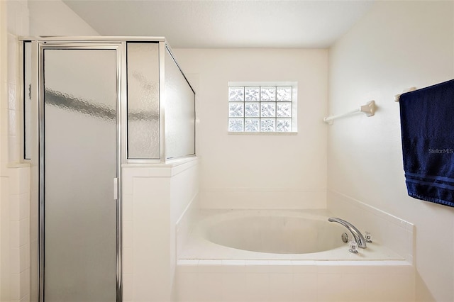 bathroom featuring shower with separate bathtub