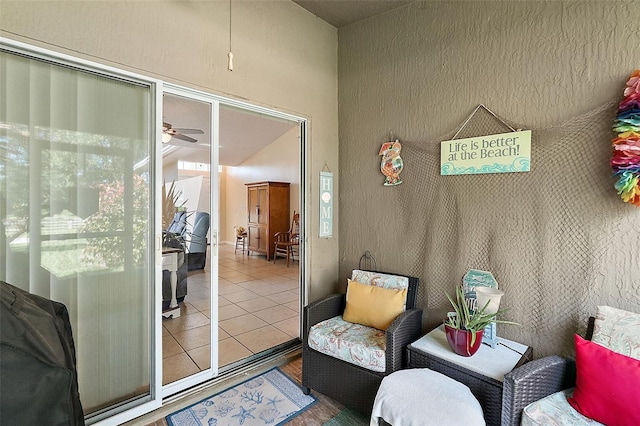 sitting room with ceiling fan and tile patterned flooring