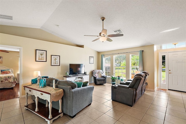 tiled living room with a textured ceiling, ceiling fan, and vaulted ceiling