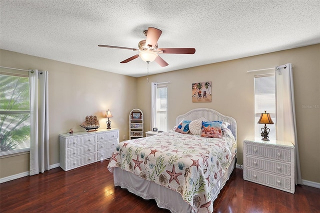 bedroom with ceiling fan, dark hardwood / wood-style flooring, and a textured ceiling