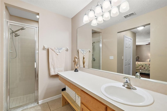 bathroom with tile patterned flooring, vanity, a textured ceiling, and an enclosed shower