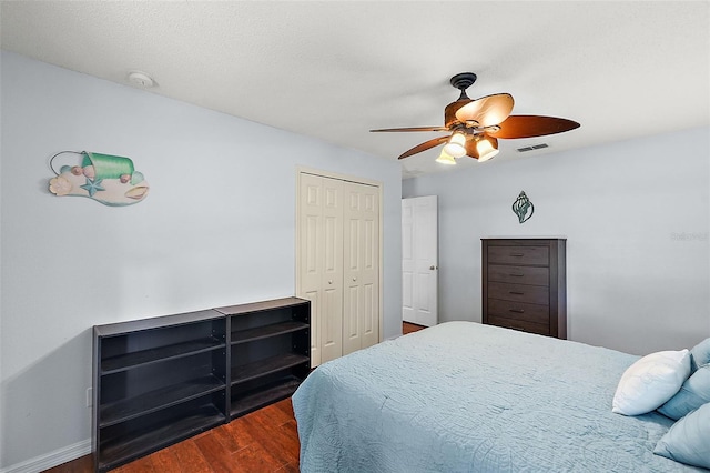 bedroom with ceiling fan, dark hardwood / wood-style flooring, and a closet