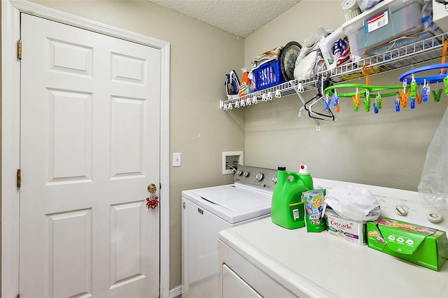 laundry area featuring a textured ceiling and washer and clothes dryer