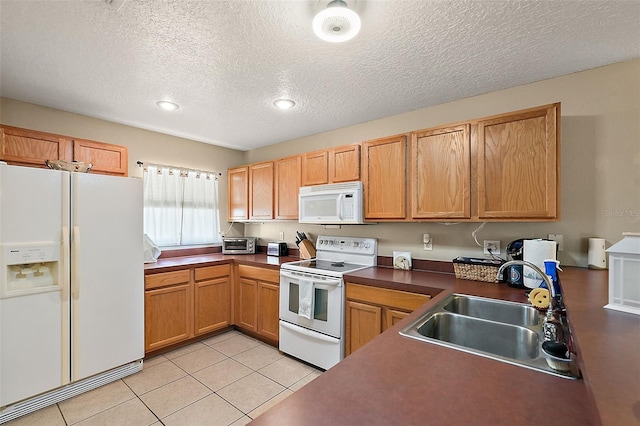 kitchen with light tile patterned flooring, white appliances, sink, and a textured ceiling