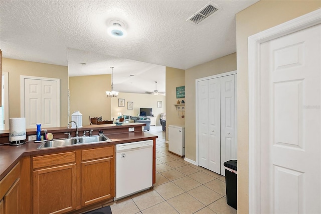 kitchen with sink, light tile patterned floors, hanging light fixtures, white dishwasher, and vaulted ceiling