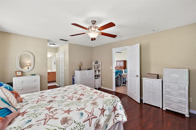 bedroom with ceiling fan, connected bathroom, dark hardwood / wood-style floors, and a textured ceiling