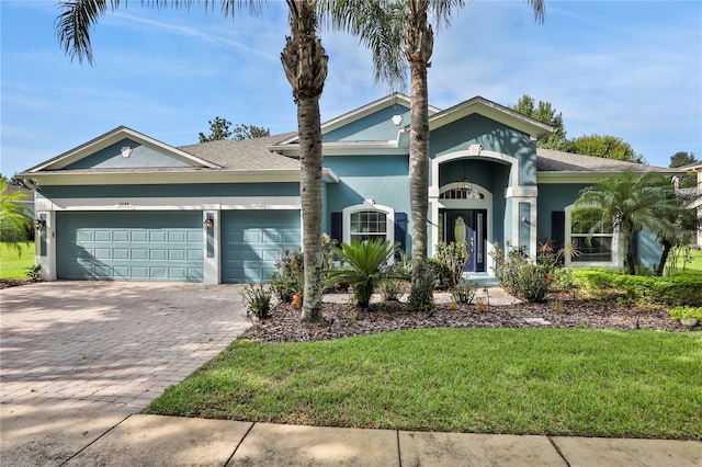 view of front of property featuring a garage and a front lawn