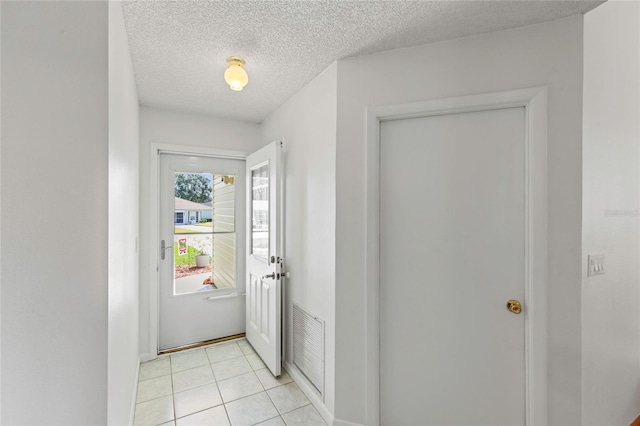 tiled entryway with a textured ceiling