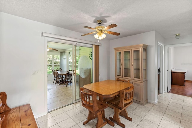 dining space featuring a textured ceiling, ceiling fan, and light tile patterned floors