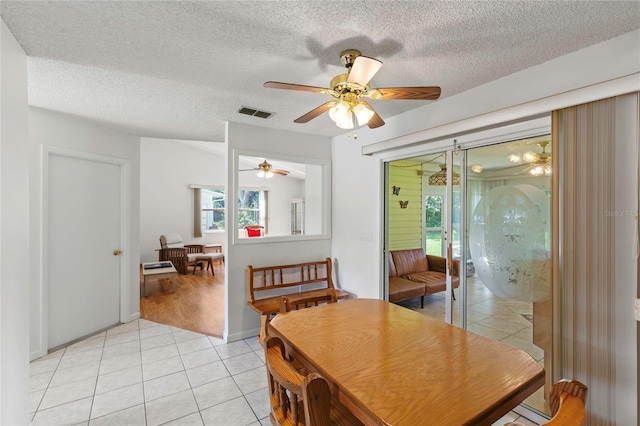 dining room with a textured ceiling, light hardwood / wood-style floors, and ceiling fan