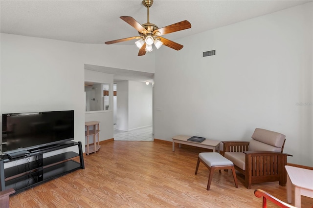 sitting room with light wood-type flooring, lofted ceiling, and ceiling fan