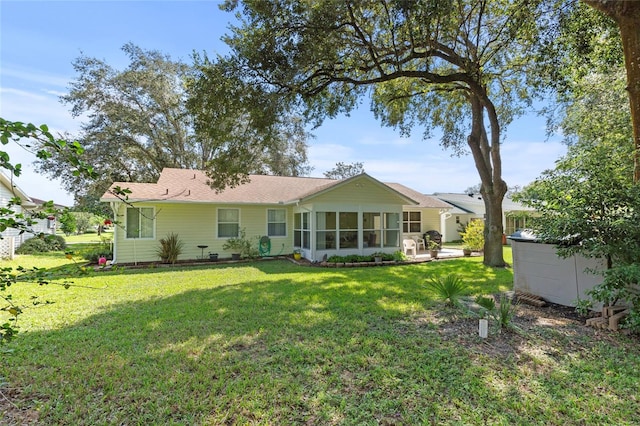 back of property with a lawn and a sunroom