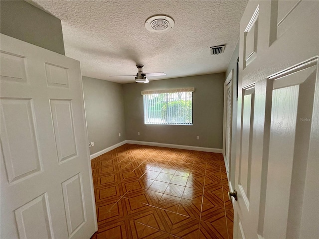 interior space featuring a textured ceiling and ceiling fan