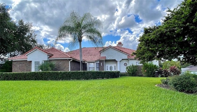 mediterranean / spanish home featuring a front yard