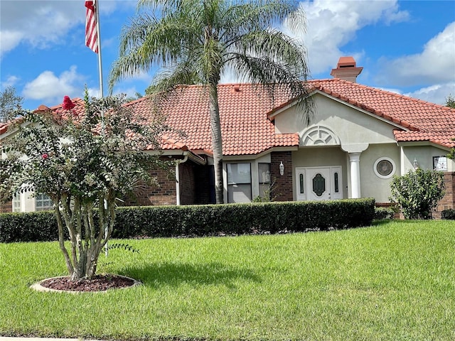 mediterranean / spanish-style house featuring a front lawn