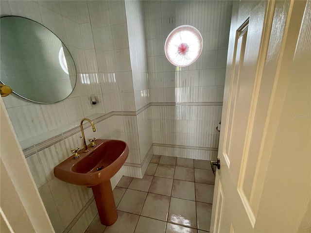 bathroom featuring tile patterned flooring, tile walls, and sink