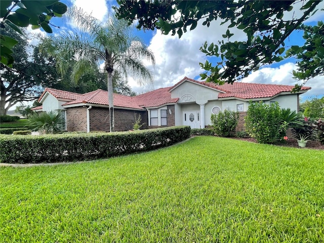 mediterranean / spanish-style home featuring a front lawn