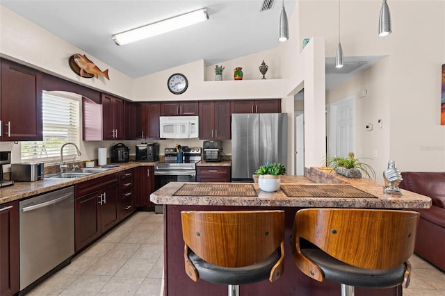 kitchen featuring light tile patterned flooring, vaulted ceiling, sink, and stainless steel appliances