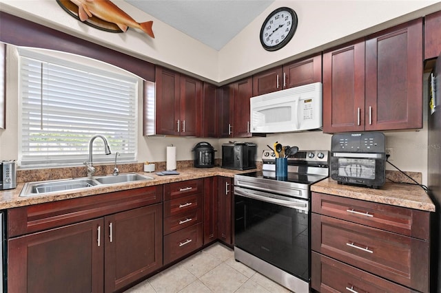 kitchen featuring light stone countertops, light tile patterned floors, lofted ceiling, sink, and stainless steel range with electric cooktop