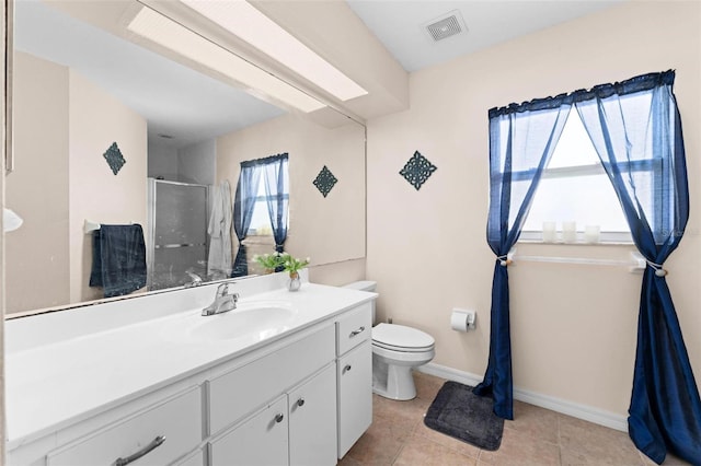 bathroom featuring vanity, toilet, tile patterned floors, and a shower with shower door