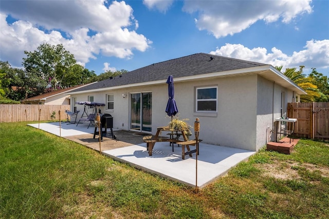 rear view of property with a lawn and a patio