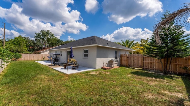 rear view of property featuring a lawn and a patio area