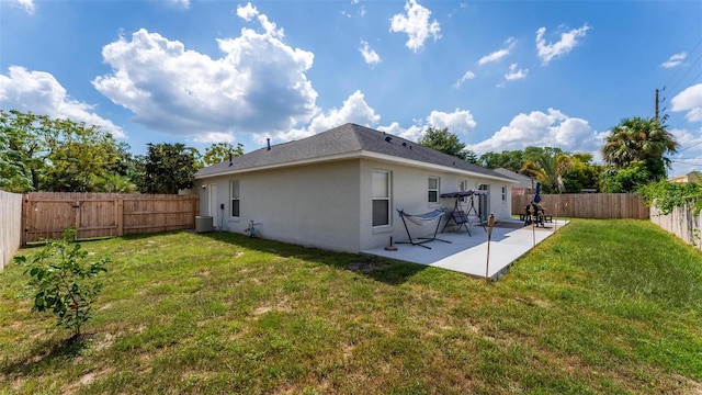 rear view of house with central AC unit, a yard, and a patio area