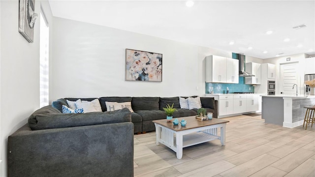 living room with sink and light hardwood / wood-style flooring