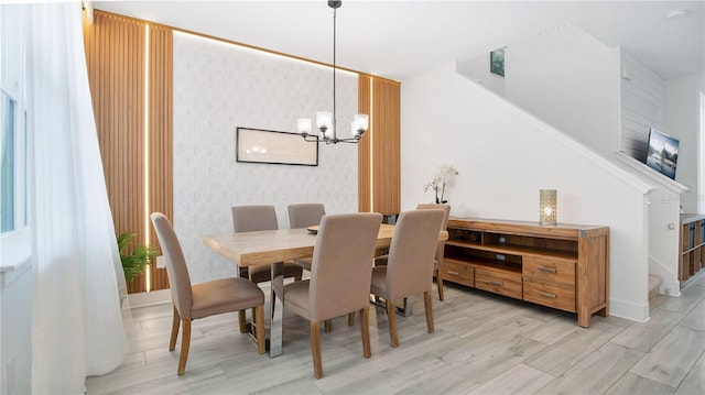 dining room with light hardwood / wood-style flooring and a notable chandelier