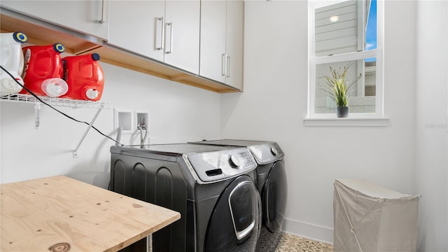 clothes washing area with cabinets and washer and dryer