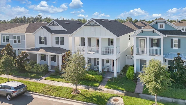 view of front of property featuring a balcony and a front lawn