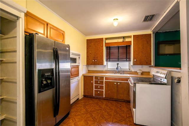 kitchen featuring washer / dryer, sink, white appliances, crown molding, and dark parquet flooring