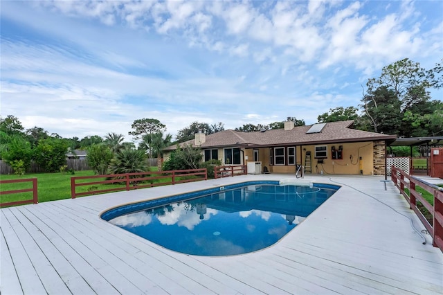 view of swimming pool featuring a patio and a wooden deck