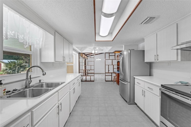 kitchen featuring ceiling fan, sink, a textured ceiling, white cabinetry, and appliances with stainless steel finishes