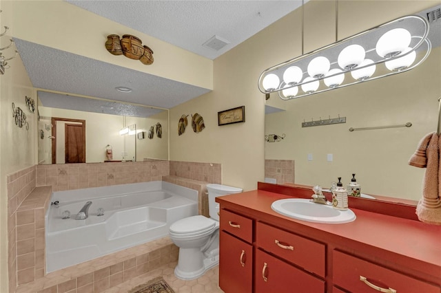 bathroom featuring vanity, a washtub, a textured ceiling, tile patterned floors, and toilet