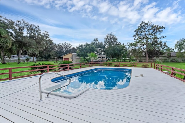 view of pool with a deck and a yard