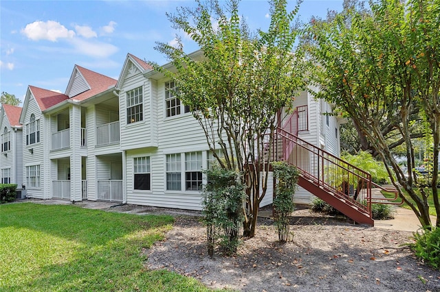 exterior space featuring a balcony and a yard