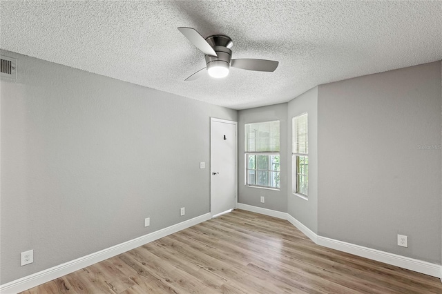 spare room with a textured ceiling, light hardwood / wood-style flooring, and ceiling fan