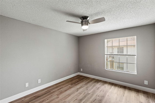 empty room featuring ceiling fan, light hardwood / wood-style flooring, and a textured ceiling