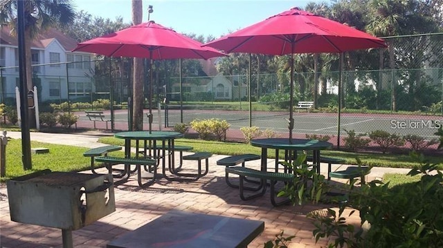 view of home's community featuring tennis court