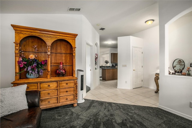 interior space featuring vaulted ceiling and light tile patterned floors