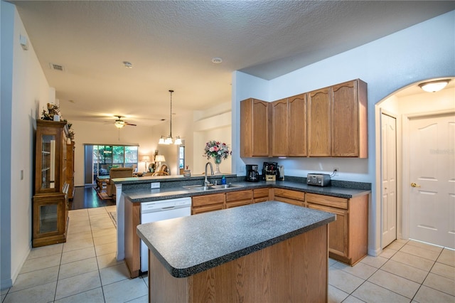 kitchen featuring pendant lighting, a textured ceiling, sink, kitchen peninsula, and ceiling fan