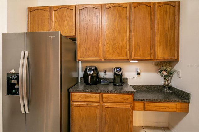 kitchen featuring stainless steel refrigerator with ice dispenser and tile patterned floors