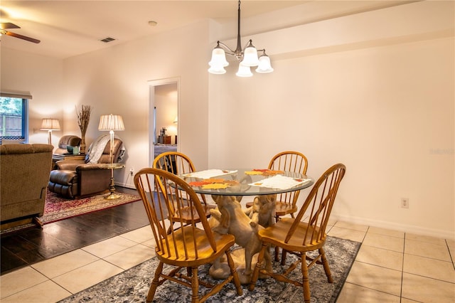 dining area with ceiling fan with notable chandelier and light wood-type flooring