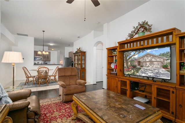 living room featuring ceiling fan with notable chandelier and wood-type flooring