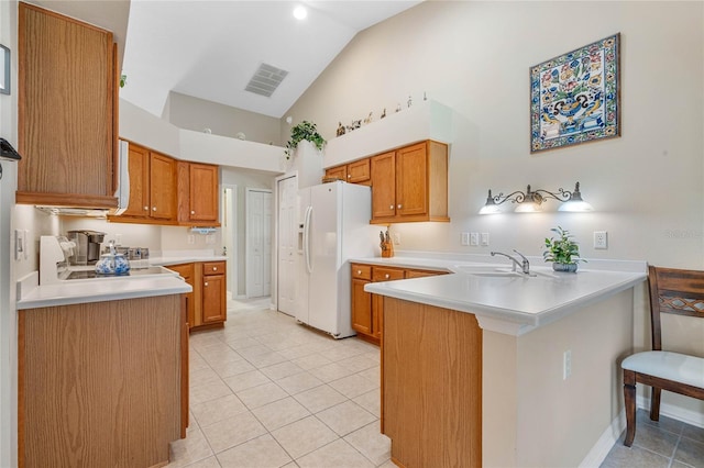 kitchen featuring white fridge with ice dispenser, light tile patterned flooring, a breakfast bar area, sink, and kitchen peninsula