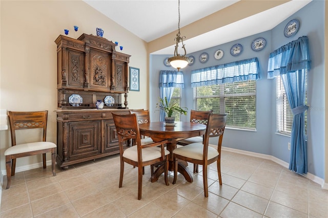 tiled dining room with lofted ceiling and plenty of natural light